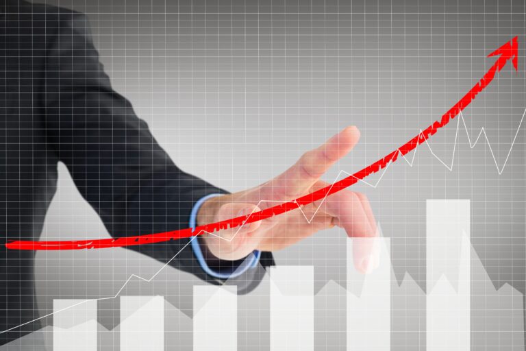 composite of businessman pointing at rising graph